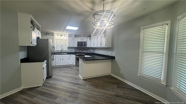 303 Nash Rd, Saint Pauls, NC 28384 - kitchen featuring stainless steel appliances, a peninsula, a sink, and dark countertops