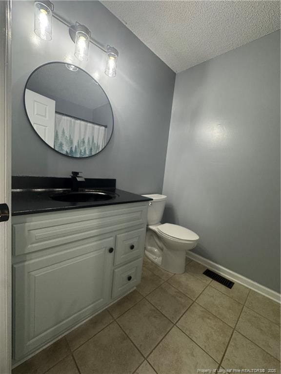303 Nash Rd, Saint Pauls, NC 28384 - bathroom with vanity, tile patterned flooring, a textured ceiling, toilet, and baseboards
