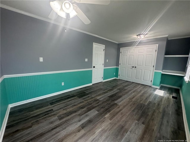 303 Nash Rd, Saint Pauls, NC 28384 - unfurnished bedroom featuring dark wood finished floors, a wainscoted wall, a closet, ceiling fan, and baseboards
