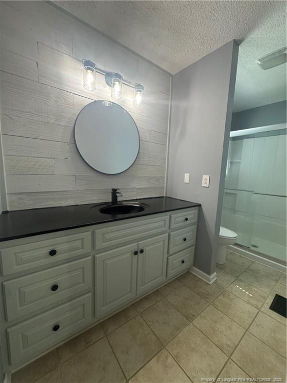 303 Nash Rd, Saint Pauls, NC 28384 - bathroom featuring vanity, tile patterned floors, a stall shower, a textured ceiling, and toilet