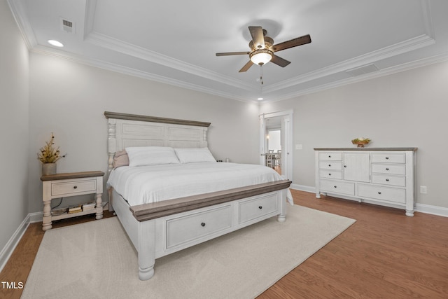 2096 Dowell Ct, Burlington, NC 27215 - bedroom featuring wood finished floors, ornamental molding, a tray ceiling, baseboards, and recessed lighting