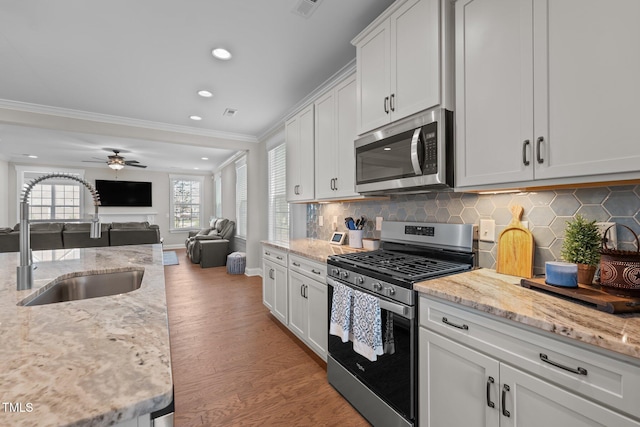 2096 Dowell Ct, Burlington, NC 27215 - kitchen featuring appliances with stainless steel finishes, a sink, ornamental molding, light wood finished floors, and decorative backsplash