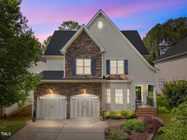 view of front facade with stone siding, concrete driveway, a garage, and a shingled roof