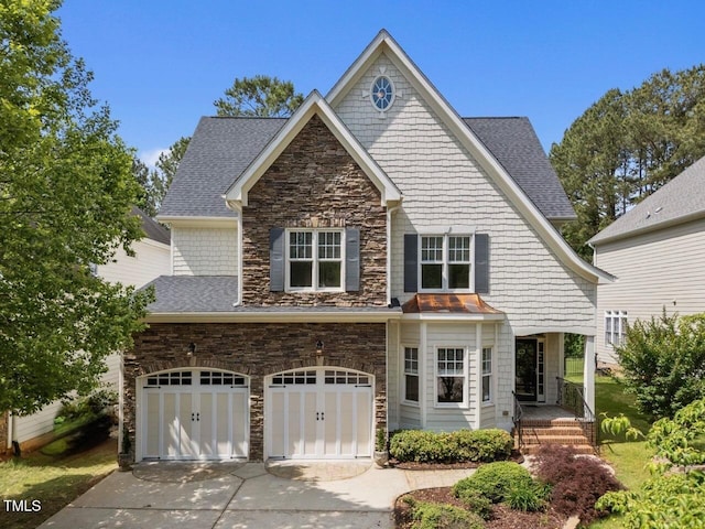 craftsman-style home with concrete driveway, stone siding, a shingled roof, and an attached garage