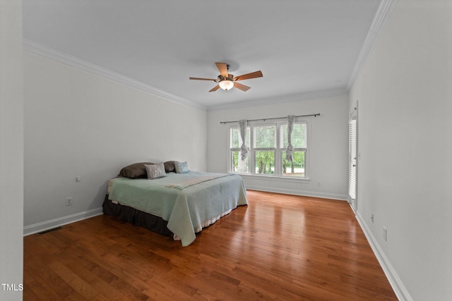 bedroom with hardwood / wood-style floors, crown molding, baseboards, and a ceiling fan