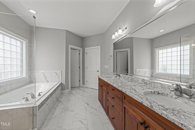 bathroom featuring marble look tiles, plenty of natural light, a bath, and double vanity