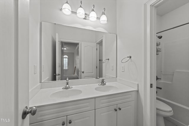 bathroom with double vanity, shower / washtub combination, and toilet
