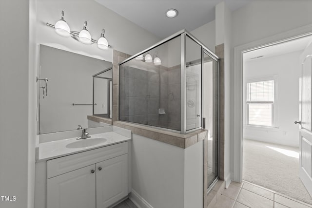 full bathroom featuring a shower stall, vanity, tile patterned floors, and baseboards