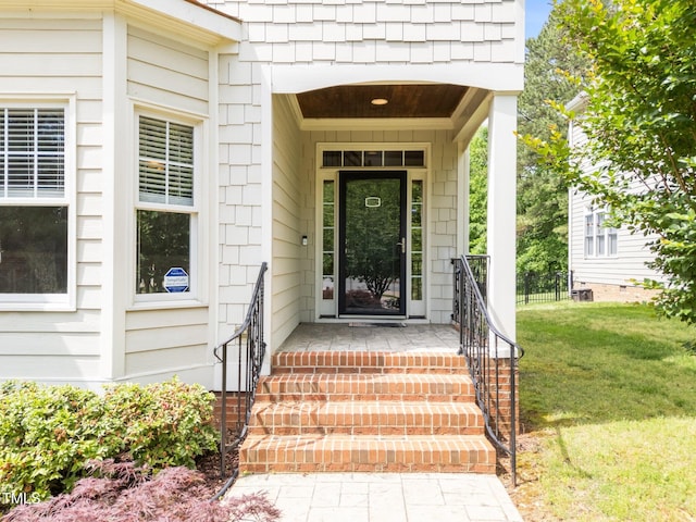 entrance to property with a lawn