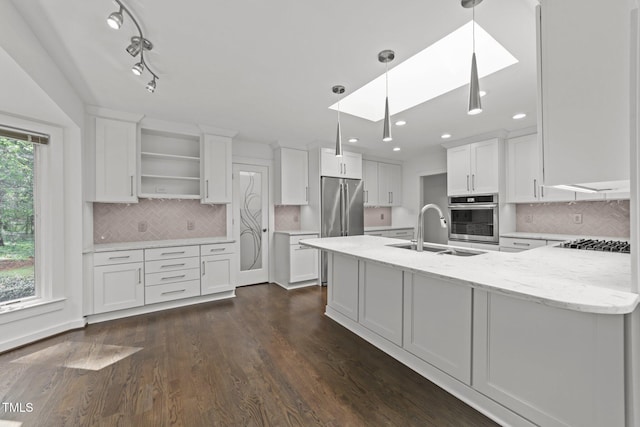 kitchen featuring stainless steel appliances, a skylight, open shelves, white cabinets, and recessed lighting