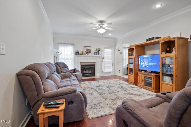 100 Jonathans Pl, Goldsboro, NC 27534 - living room featuring crown molding, ceiling fan, wood finished floors, a fireplace with flush hearth, and arched walkways