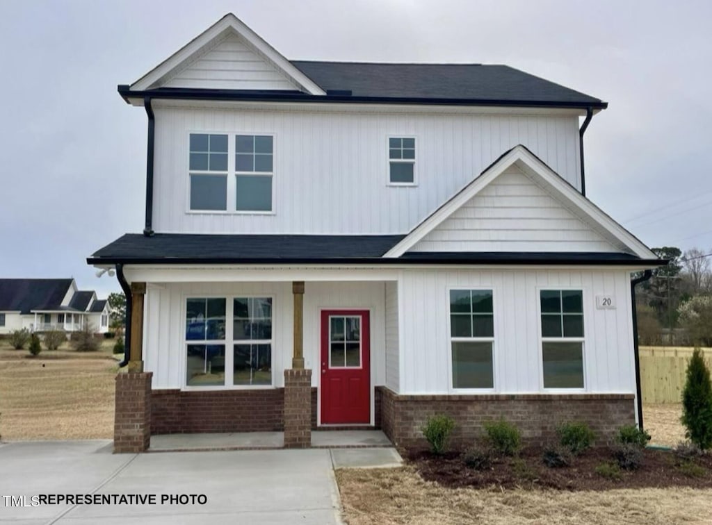 view of front of property with a porch, brick siding, and board and batten siding