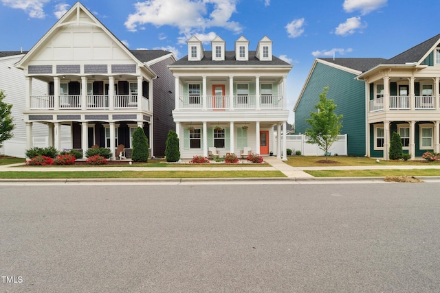 view of front of home featuring a balcony, fence, and covered porch