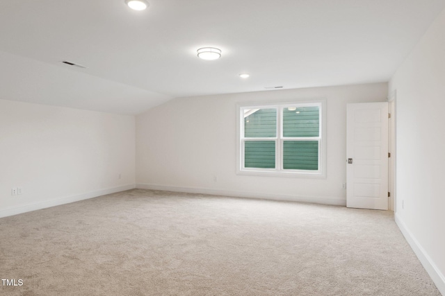 additional living space with light carpet, lofted ceiling, baseboards, and recessed lighting