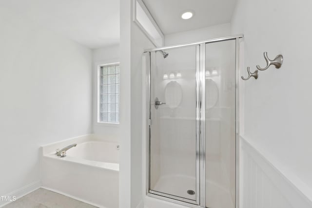 bathroom featuring a stall shower, a garden tub, and tile patterned flooring