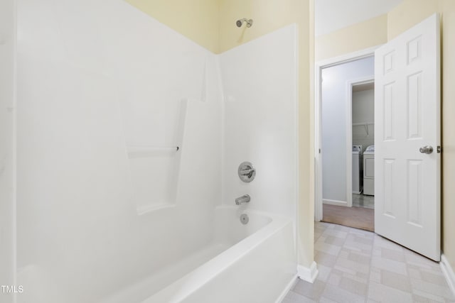 full bath featuring separate washer and dryer, tile patterned floors, baseboards, and shower / bath combination