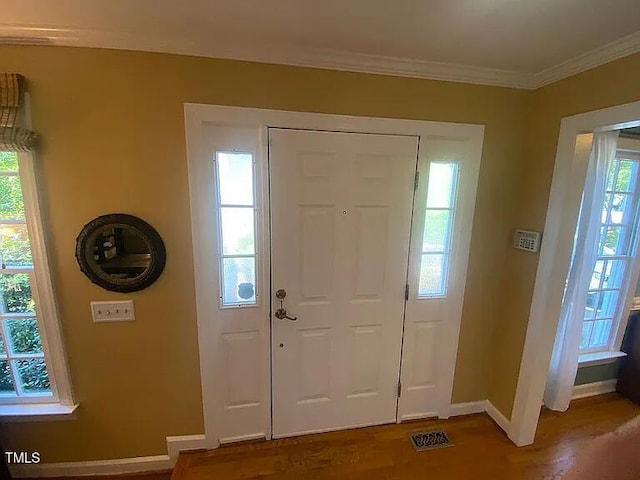 entryway featuring wood finished floors, baseboards, and ornamental molding