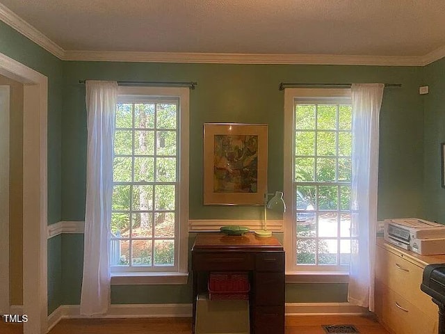 entryway with healthy amount of natural light, ornamental molding, baseboards, and wood finished floors