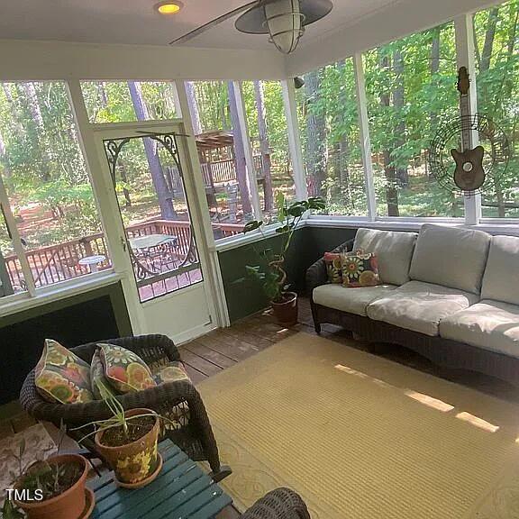 sunroom featuring an outdoor living space and a ceiling fan