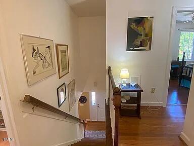 stairway with wood finished floors and baseboards