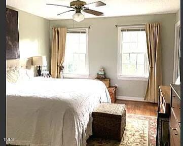 bedroom with wood finished floors, baseboards, and a ceiling fan