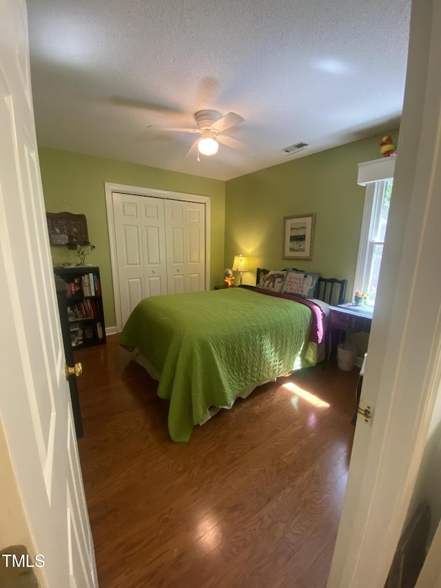 bedroom with wood finished floors, a closet, a ceiling fan, and a textured ceiling