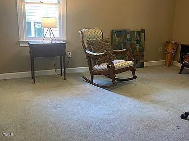 living area featuring carpet floors and baseboards