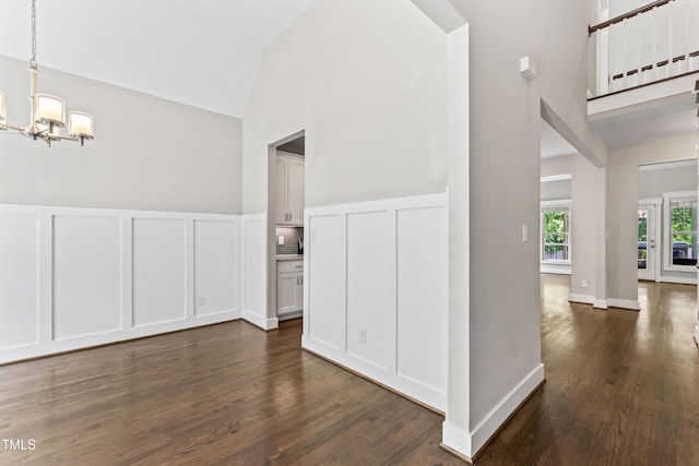 3914 Old Chapel Hill Rd, Durham, NC 27707 - unfurnished room featuring high vaulted ceiling, a chandelier, dark wood-style flooring, and a decorative wall