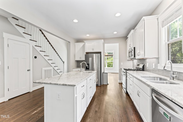 3914 Old Chapel Hill Rd, Durham, NC 27707 - kitchen with appliances with stainless steel finishes, a sink, dark wood-style floors, tasteful backsplash, and white cabinetry