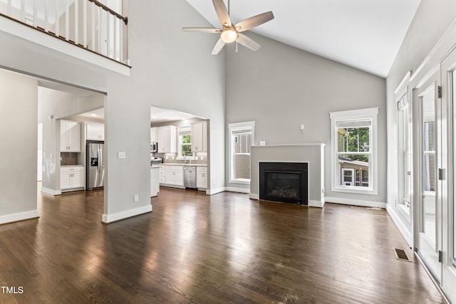 3914 Old Chapel Hill Rd, Durham, NC 27707 - unfurnished living room with ceiling fan, high vaulted ceiling, a glass covered fireplace, and dark wood finished floors