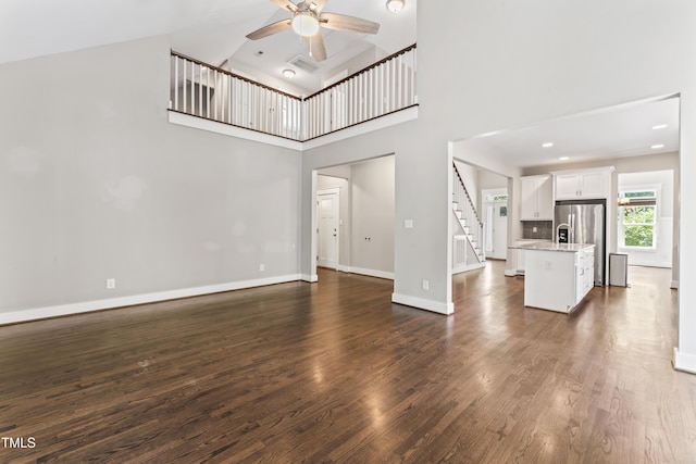 3914 Old Chapel Hill Rd, Durham, NC 27707 - unfurnished living room with a ceiling fan, high vaulted ceiling, stairs, dark wood-type flooring, and baseboards