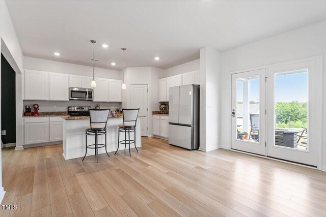 637 Marrian Dr, Clayton, NC 27520 - kitchen with appliances with stainless steel finishes, recessed lighting, a breakfast bar, white cabinets, and light wood-style floors