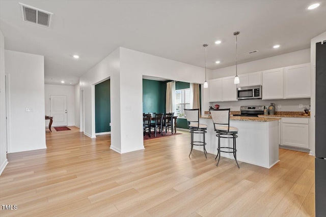 637 Marrian Dr, Clayton, NC 27520 - kitchen with appliances with stainless steel finishes, light wood finished floors, white cabinets, recessed lighting, and light stone counters