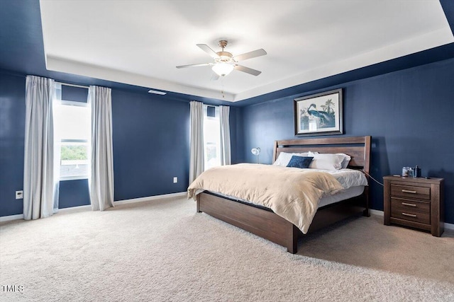637 Marrian Dr, Clayton, NC 27520 - carpeted bedroom featuring multiple windows, a tray ceiling, and baseboards