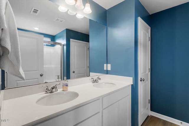 637 Marrian Dr, Clayton, NC 27520 - bathroom featuring a shower stall, wood finished floors, double vanity, and baseboards