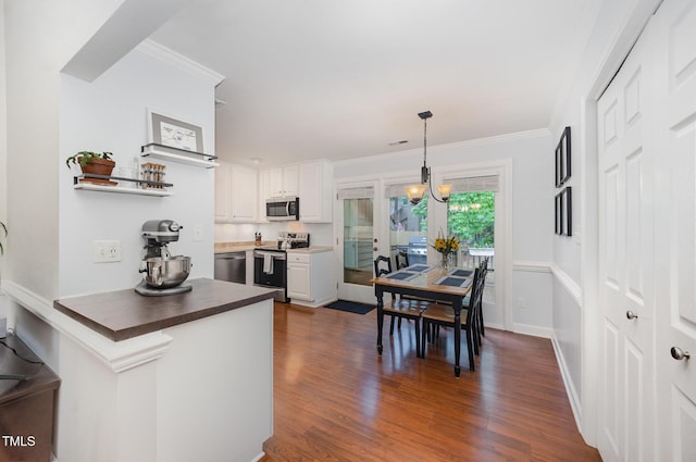 200 W Woodcroft Pkwy Unit 57B, Durham, NC 27713 - kitchen with stainless steel appliances, crown molding, dark wood finished floors, a peninsula, and hanging light fixtures