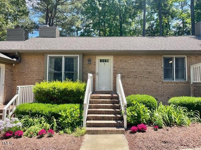 200 W Woodcroft Pkwy Unit 57B, Durham, NC 27713 - property entrance with brick siding, a chimney, and a shingled roof