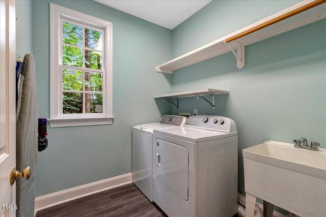 washroom with washing machine and dryer, dark wood-style floors, and baseboards