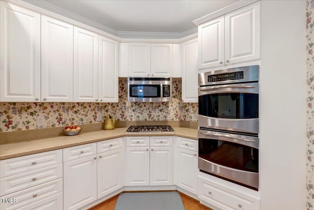 kitchen with appliances with stainless steel finishes, light countertops, and white cabinets
