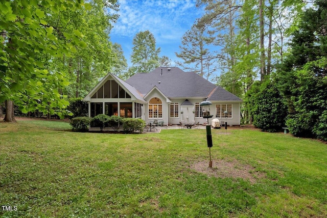 rear view of house with a patio area, a sunroom, and a yard
