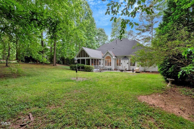 back of house with a sunroom and a yard