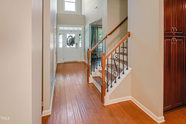 82 Idlewood Ln, Clayton, NC 27527 - entryway with light wood-style floors, stairway, baseboards, and a towering ceiling