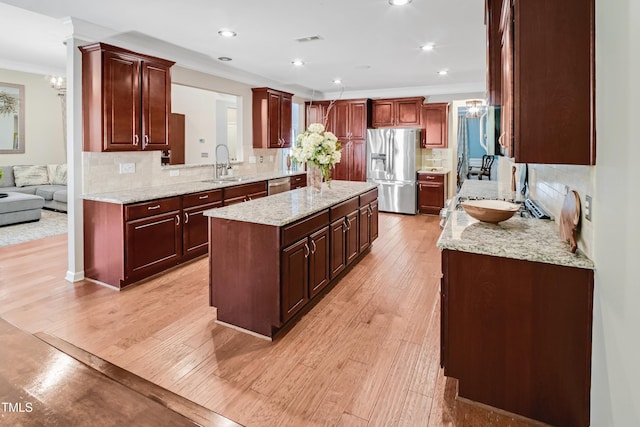 82 Idlewood Ln, Clayton, NC 27527 - kitchen with appliances with stainless steel finishes, a sink, crown molding, a kitchen island, and tasteful backsplash