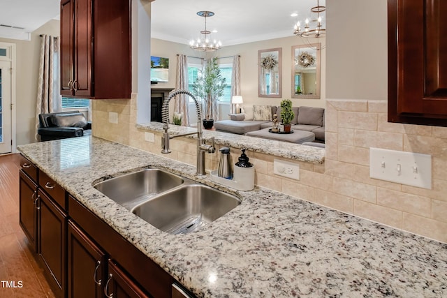 82 Idlewood Ln, Clayton, NC 27527 - kitchen featuring a sink, a chandelier, light stone countertops, open floor plan, and wood finished floors