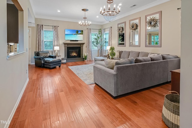82 Idlewood Ln, Clayton, NC 27527 - living room with a chandelier, light wood-type flooring, crown molding, a glass covered fireplace, and baseboards