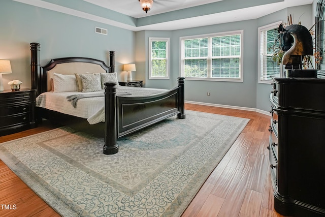 82 Idlewood Ln, Clayton, NC 27527 - bedroom featuring light wood-style flooring, baseboards, and a tray ceiling