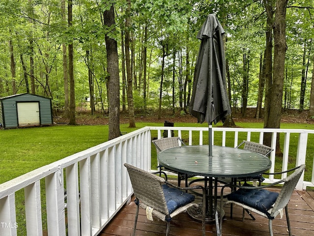 wooden deck with outdoor dining area, a storage shed, an outbuilding, and a lawn