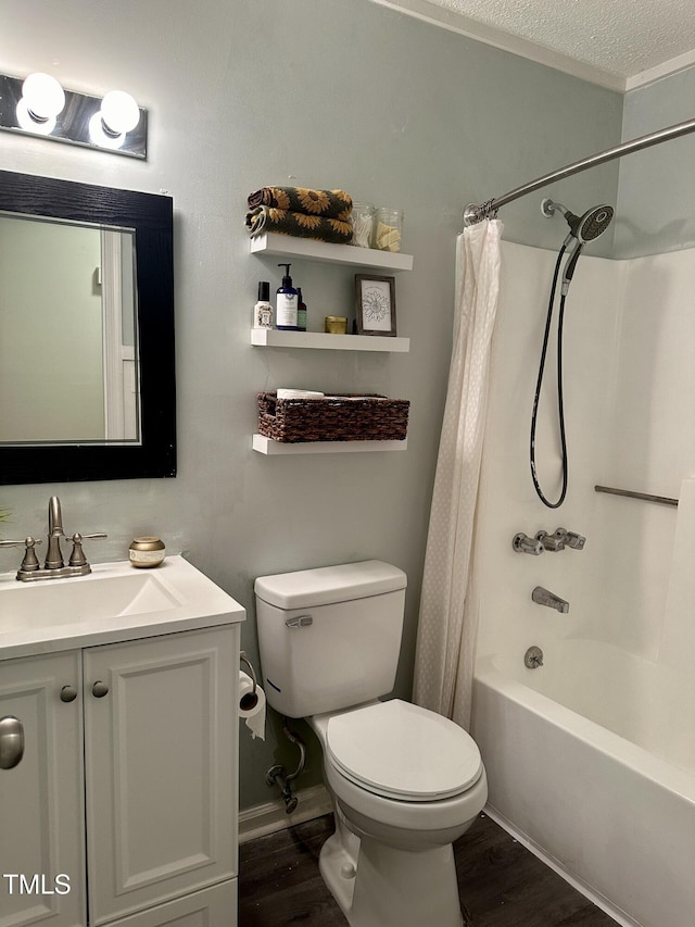 bathroom featuring wood finished floors, toilet, shower / bath combination with curtain, vanity, and a textured ceiling