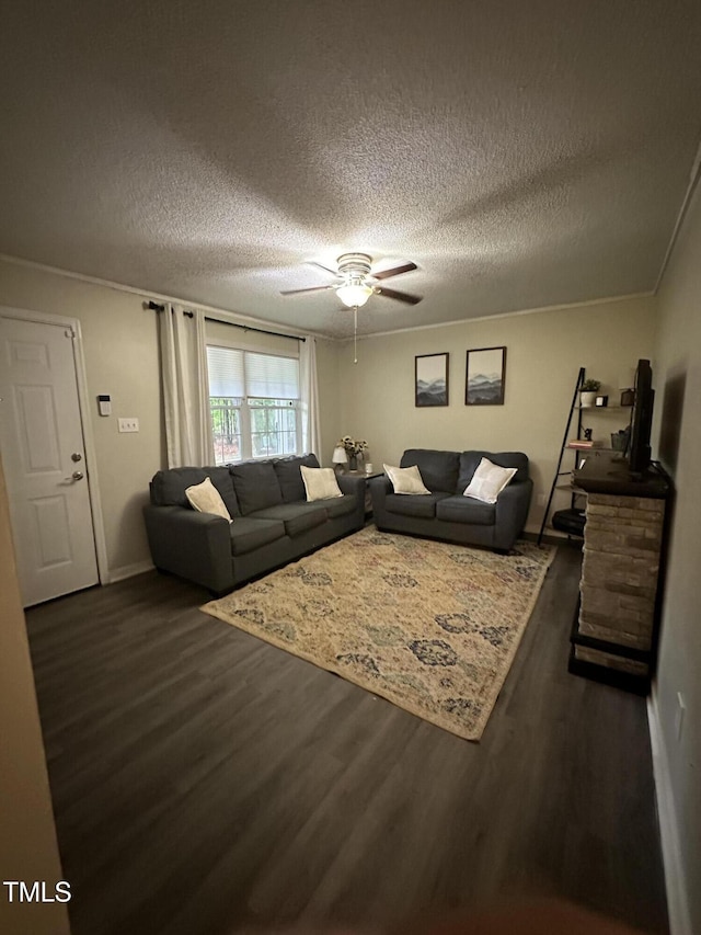 living room with wood finished floors, a ceiling fan, a textured ceiling, and baseboards