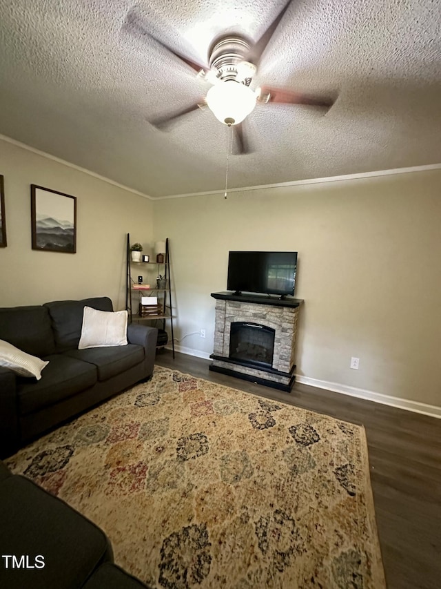 living room with a textured ceiling, dark wood-style flooring, a ceiling fan, baseboards, and a fireplace